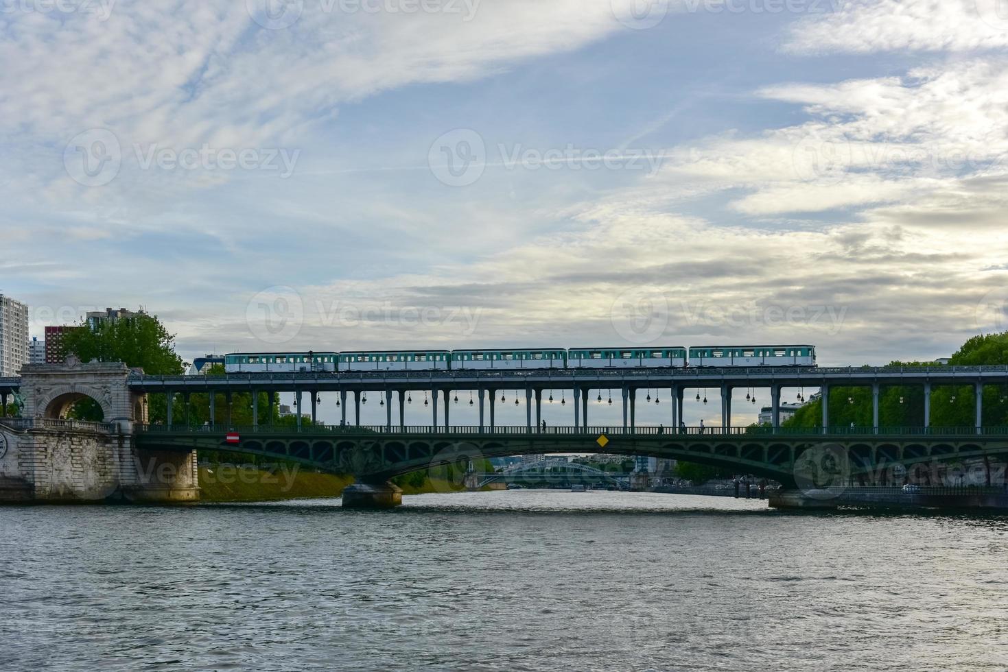 tren que pasa por el famoso puente pont de bir-hakeim que cruza el río sena en parís, francia foto