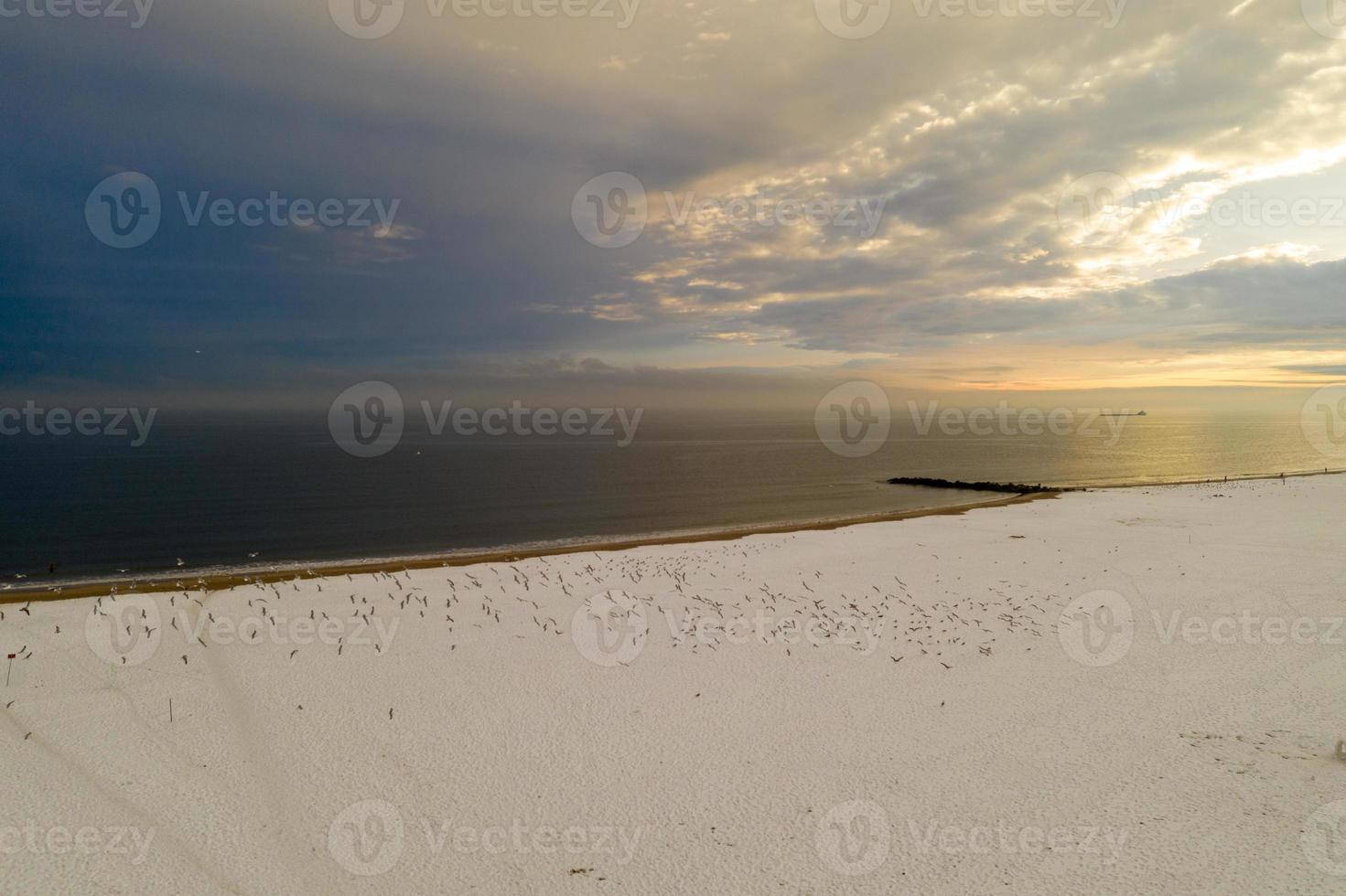 Aerial view of a snow covered Coney Island Beach during the winter at sunset in Brooklyn, New York photo