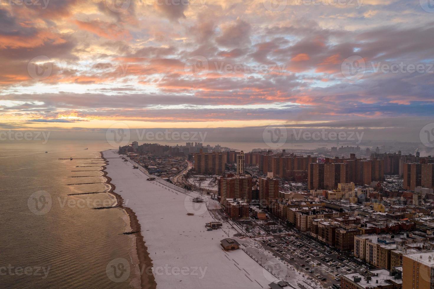 vista aérea de una playa de coney island cubierta de nieve durante el invierno al atardecer en brooklyn, nueva york foto