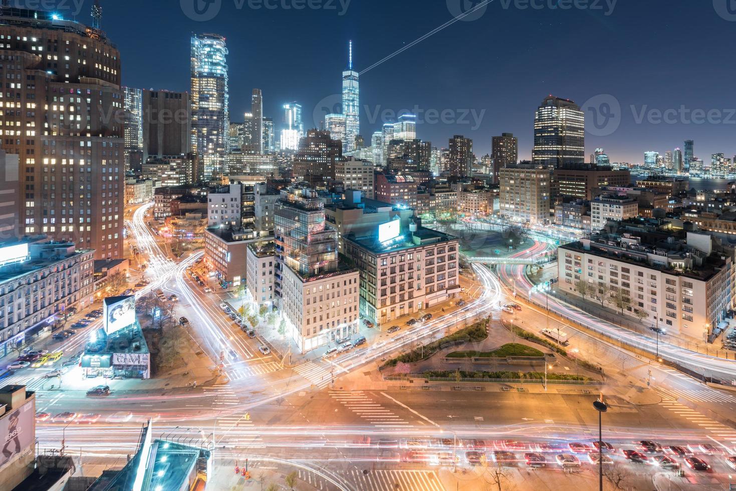 The skyline of downtown Manhattan, New York at sunset with trails of traffic in the street. photo