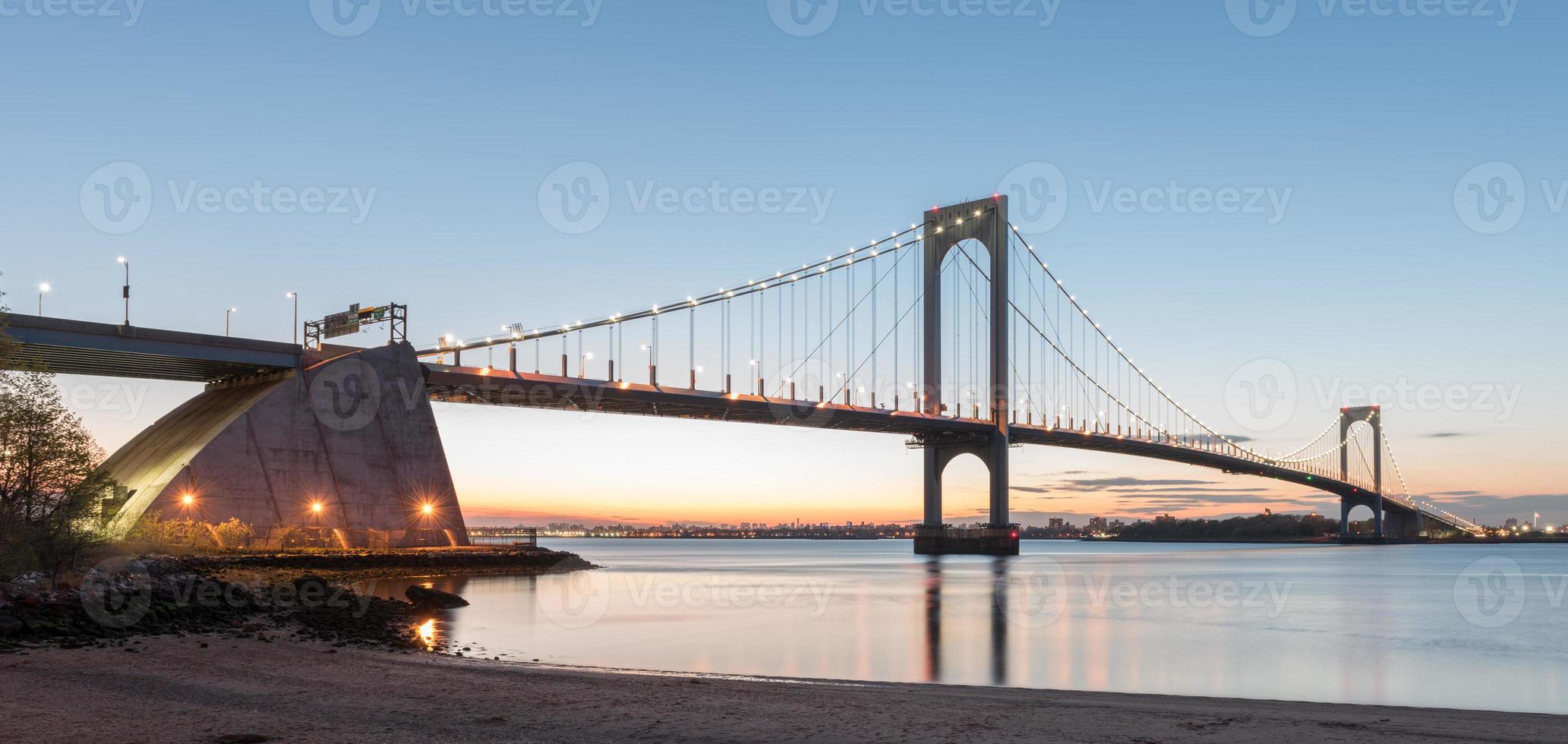 The Bronx-Whitestone Bridge reflecting on the East River at night in New York. photo