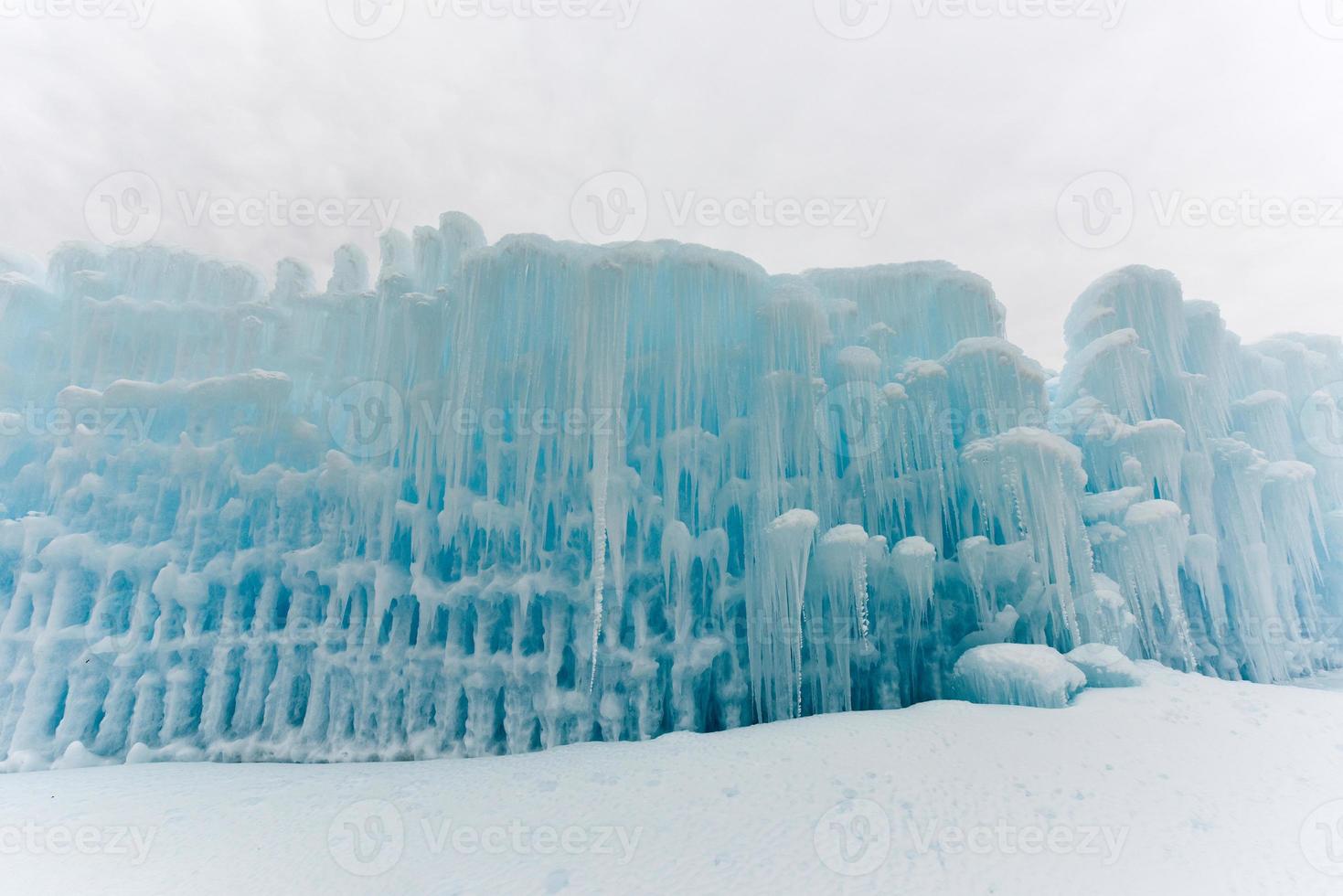 Translucent blue icicles in a frozen ice wall. photo