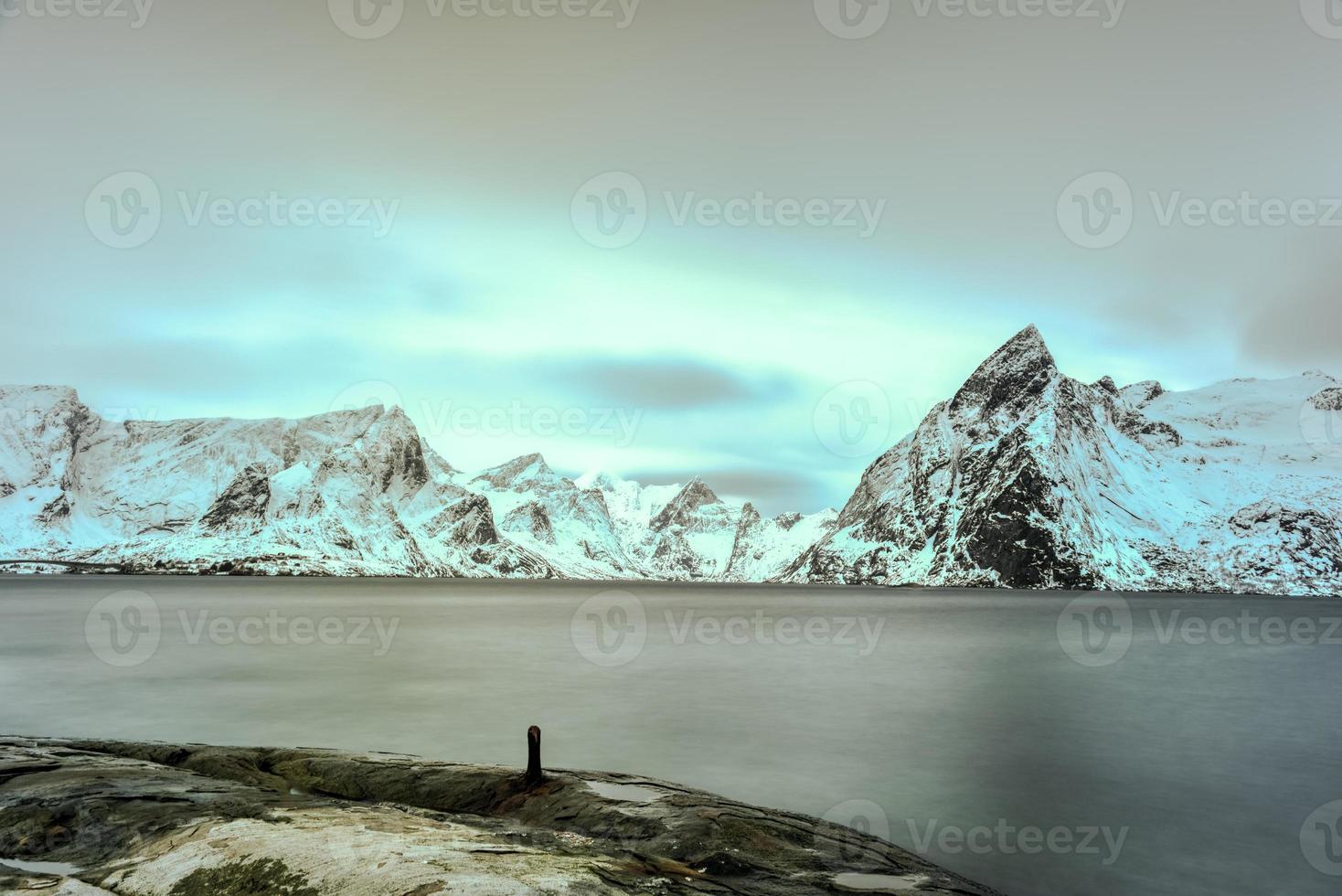 cabaña de pesca en el pico de la montaña hamnoy y lilandstinden en invierno en reine, islas lofoten, noruega. foto