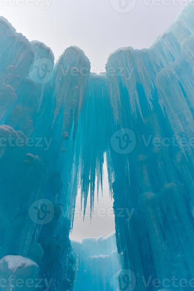 Translucent blue icicles in a frozen ice wall. photo