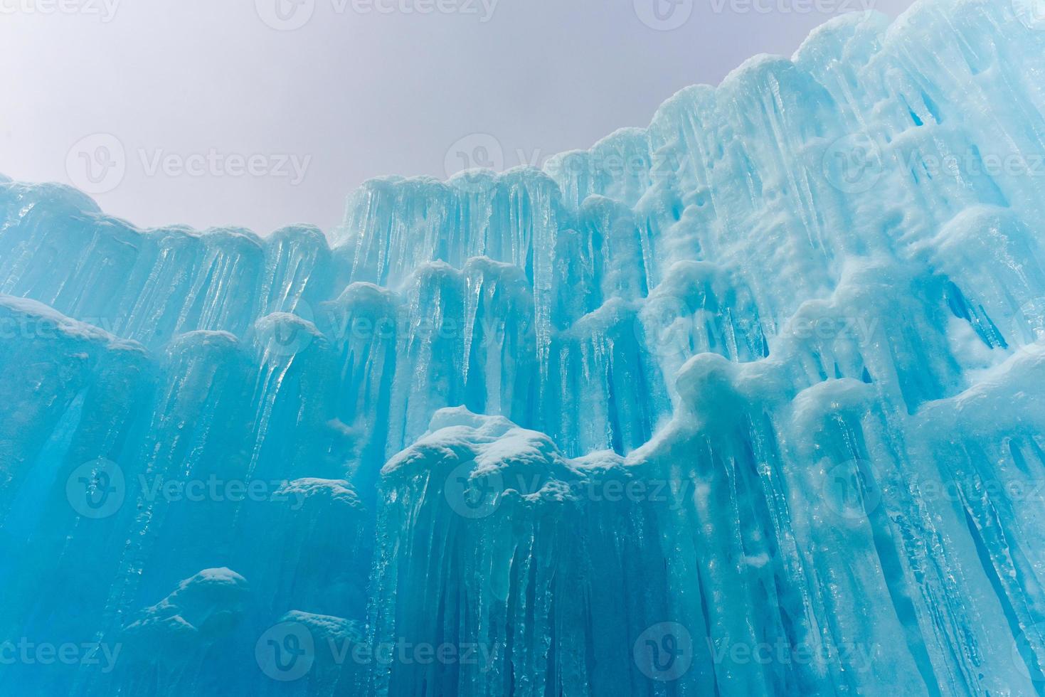 Translucent blue icicles in a frozen ice wall. photo
