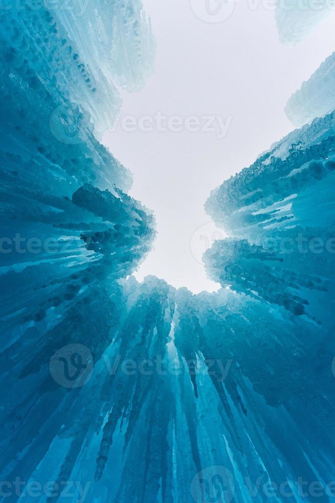 Translucent blue icicles in a frozen ice wall. photo