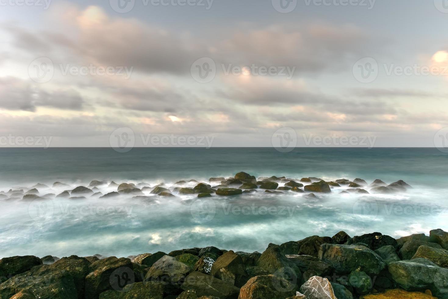 Beach with waves crossing against the rocks off of San Juan, Puerto Rico. photo