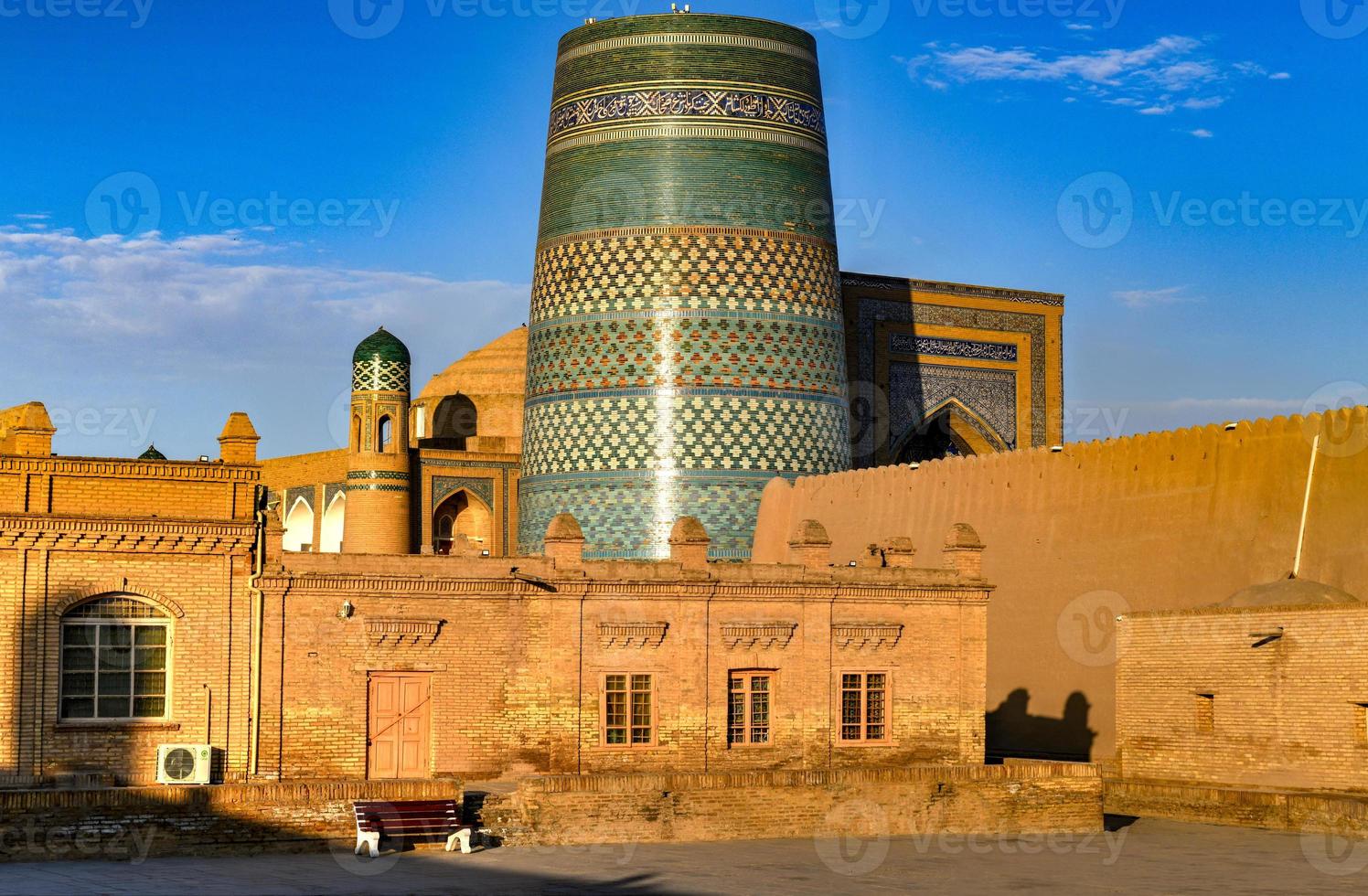 Kalta Minor Minaret and the historic architecture of Itchan Kala, walled inner town of the city of Khiva, Uzbekistan a UNESCO World Heritage Site. photo
