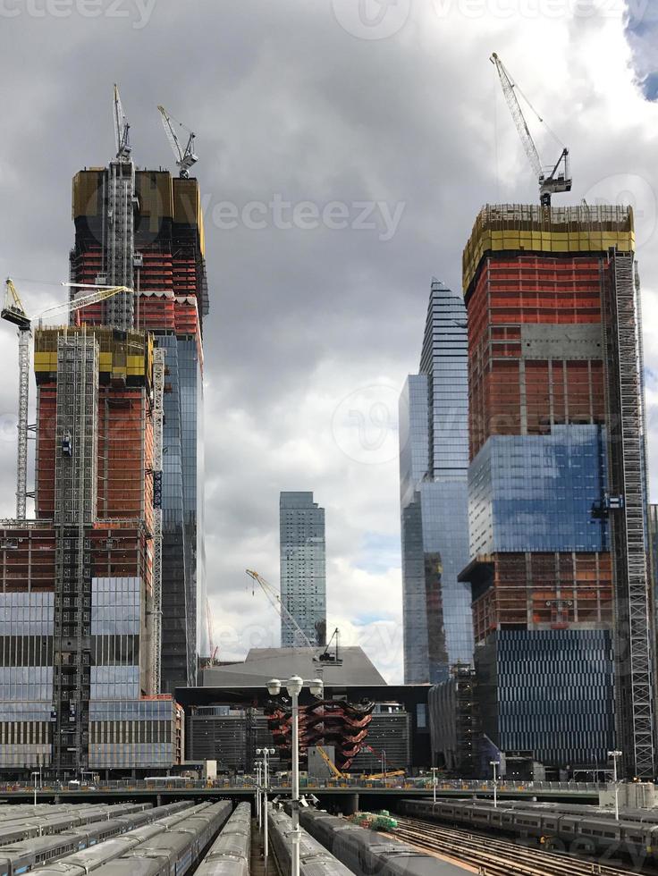 View of the Hudson Yards train depot and building development seen from the High Line, an elevated green urban park running along old rail track lines in New York City. photo