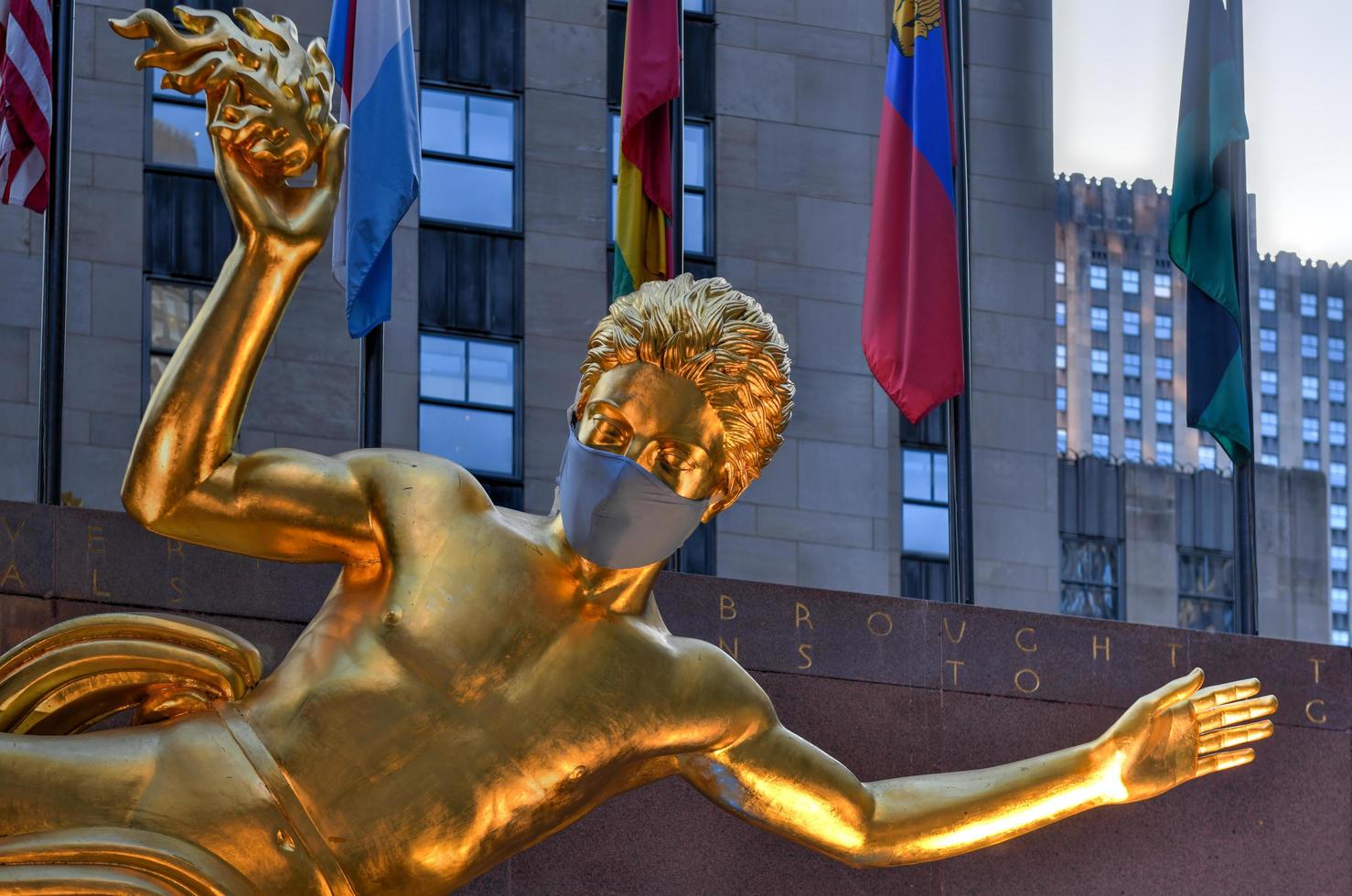 New York, NY, USA - Jul 2, 2020 -  Real estate firm Tishman Speyer fitted masks on Prometheus and other classic statues in Rockefeller Center to remind New Yorkers to wear COVID-19 face coverings. photo