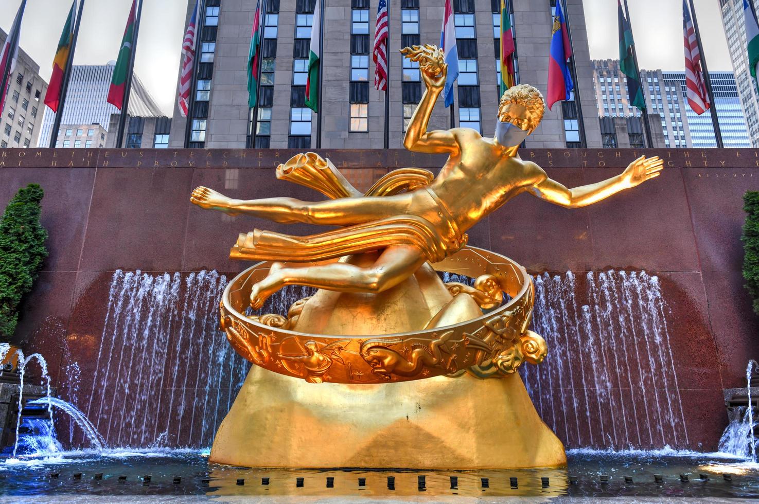 New York, NY, USA - Jul 2, 2020 -  Real estate firm Tishman Speyer fitted masks on Prometheus and other classic statues in Rockefeller Center to remind New Yorkers to wear COVID-19 face coverings. photo