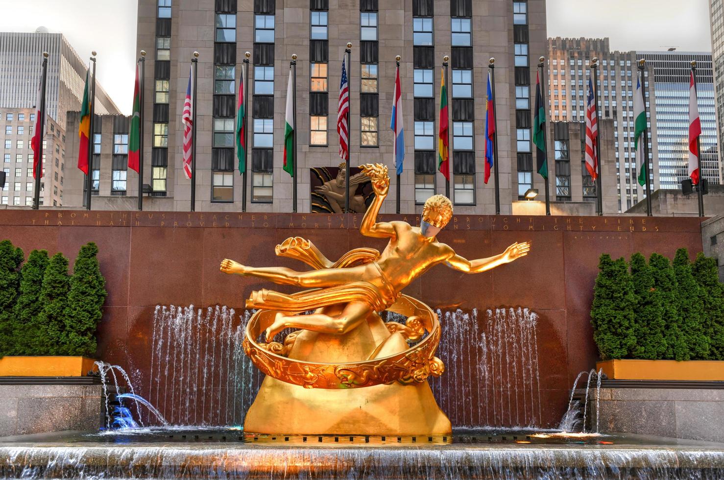 New York, NY, USA - Jul 2, 2020 -  Real estate firm Tishman Speyer fitted masks on Prometheus and other classic statues in Rockefeller Center to remind New Yorkers to wear COVID-19 face coverings. photo