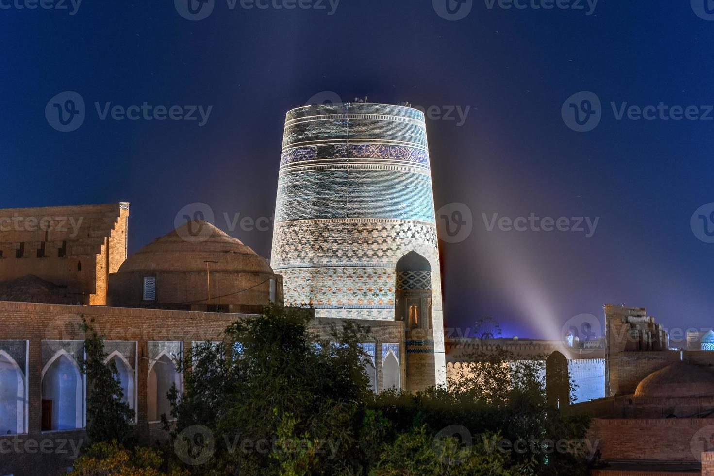 Kalta Minor Minaret and the historic architecture of Itchan Kala, walled inner town of the city of Khiva, Uzbekistan a UNESCO World Heritage Site. photo