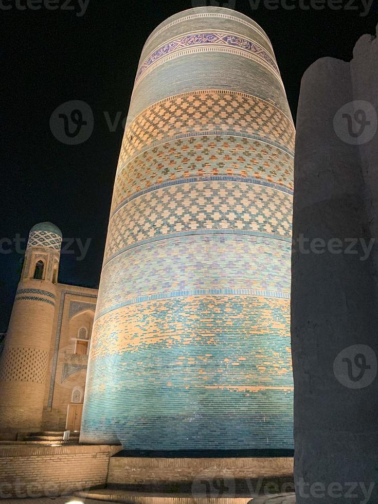 Kalta Minor Minaret and the historic architecture of Itchan Kala, walled inner town of the city of Khiva, Uzbekistan a UNESCO World Heritage Site. photo