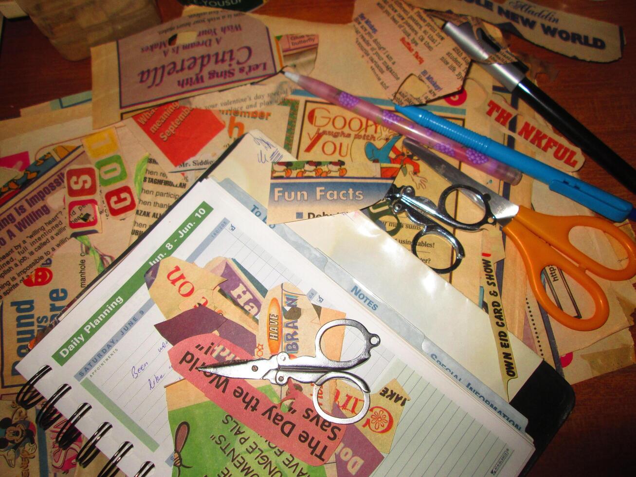 Scrapbooking Supplies and Newspaper Cuttings Scattered On Table In