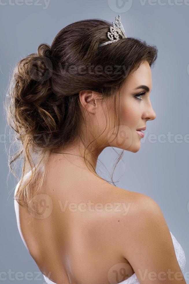 Beautiful bride with a stylish hairdo isolated on gray background photo