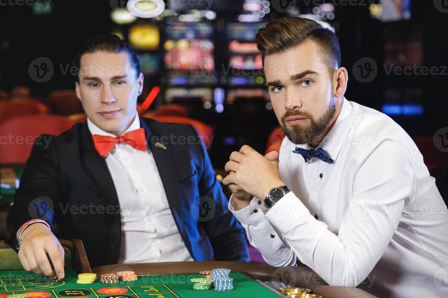 Handsome guys playing roulette in the casino photo