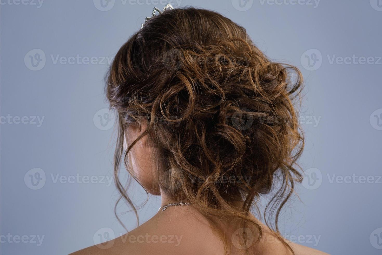 Beautiful bride with a stylish hairdo isolated on gray background photo