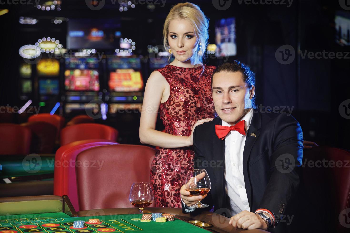 Beautiful and rich couple playing roulette in the casino photo