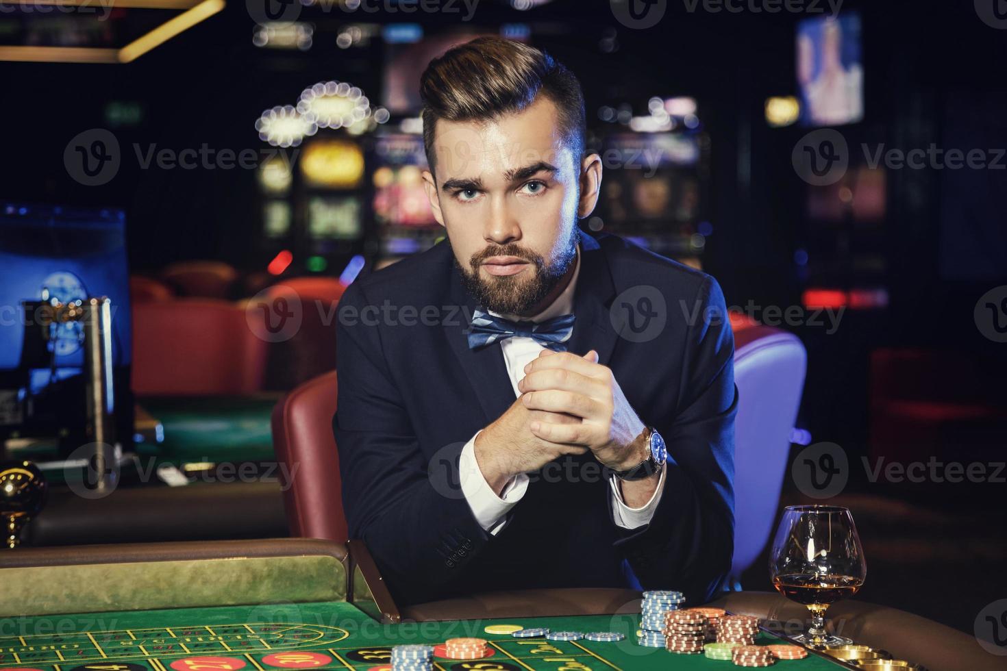 hombre guapo jugando a la ruleta en el casino foto