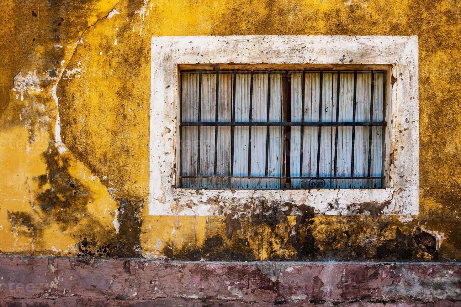 Old window and wall of colorful grungy house photo