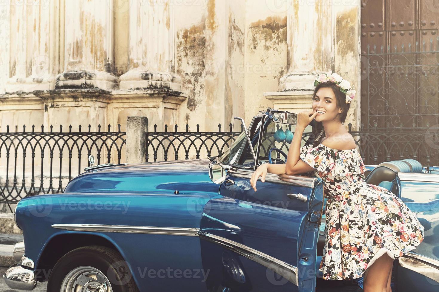 Portrait of woman in beautiful dress beside a retro car photo