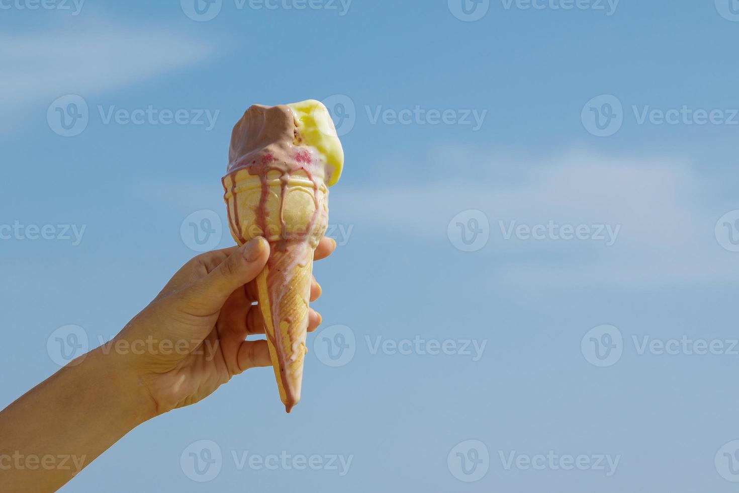 Jand with an ice cream cone and blue sky photo