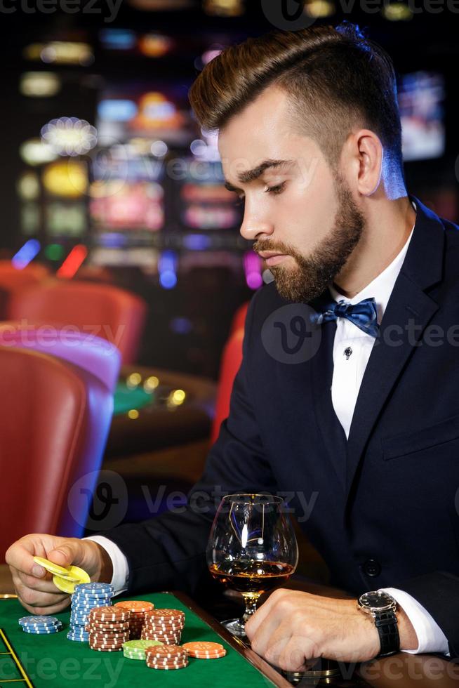 Handsome man playing roulette in the casino photo