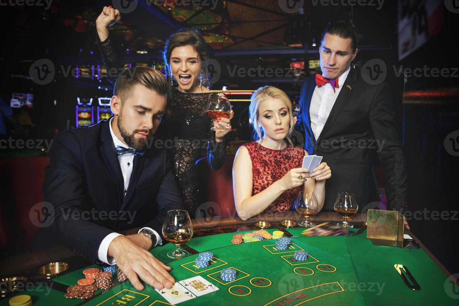 Group of rich people is playing poker in the casino photo