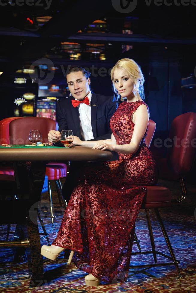 Beautiful and rich couple playing roulette in the casino photo