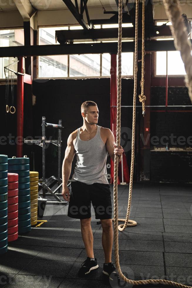 Young muscular guy during his cross training workout photo