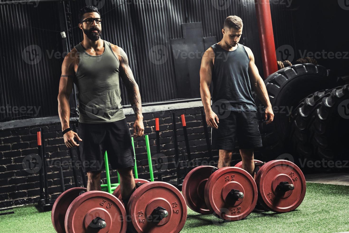 Muscular men during competition in the farmer's walk exercise photo