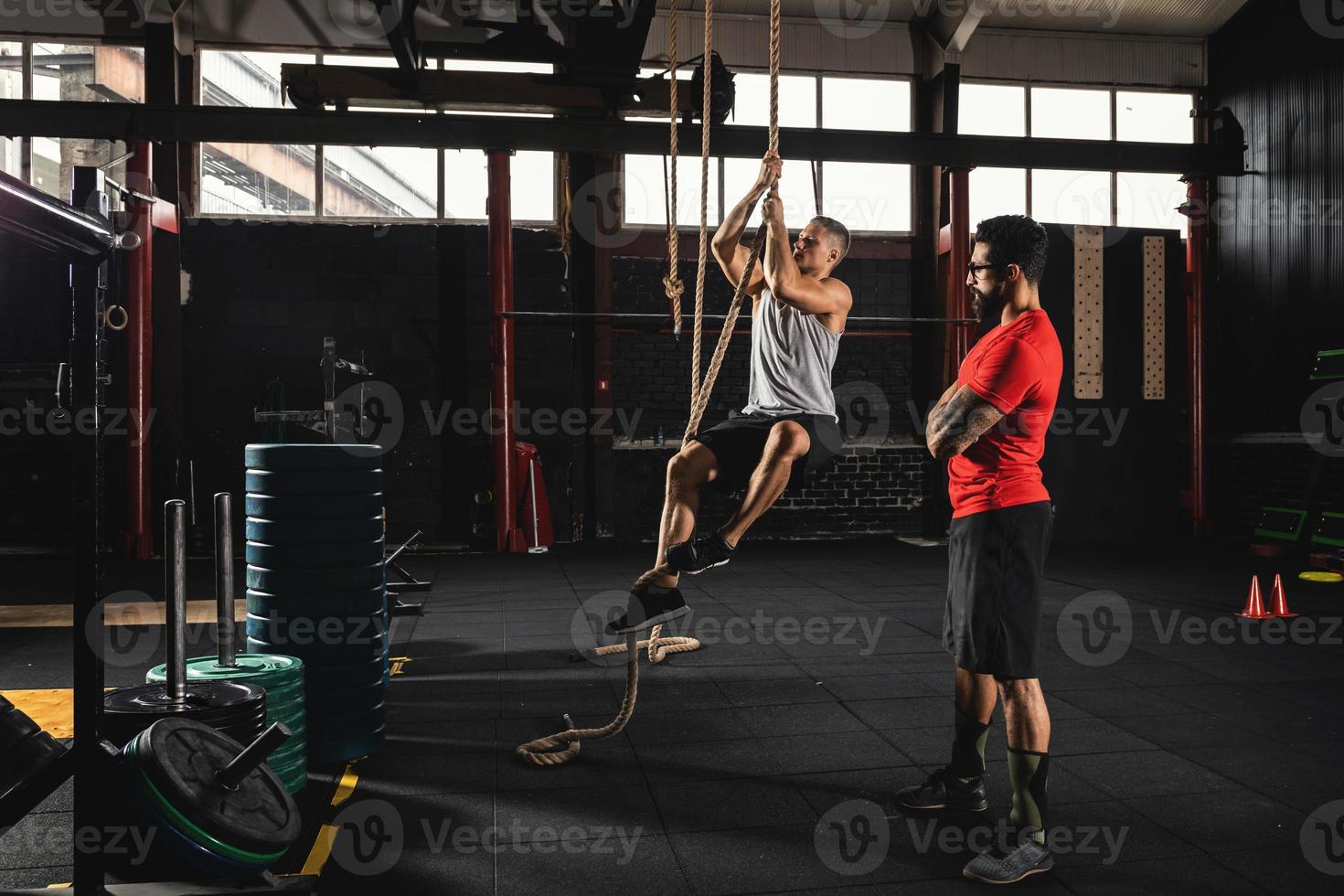 Sportsman and his trainer during workout in the gym photo