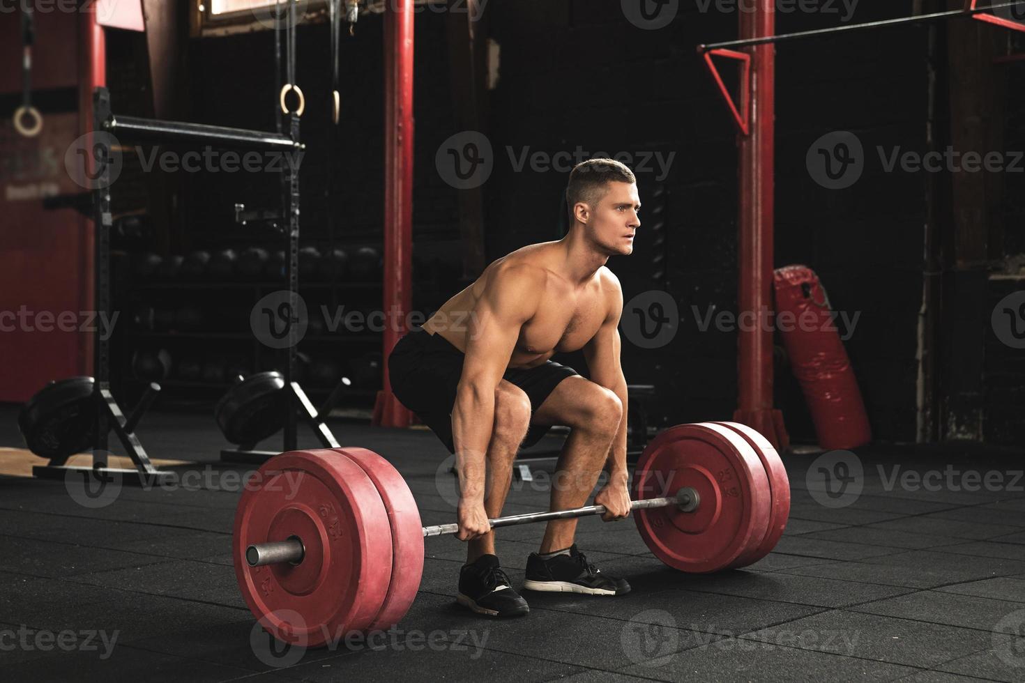 Deadlift exercise. Man during his workout in the gym photo