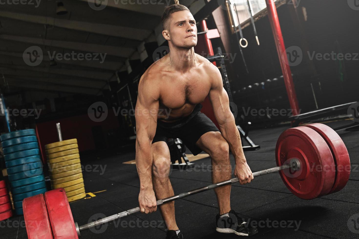 Deadlift exercise. Man during his workout in the gym photo