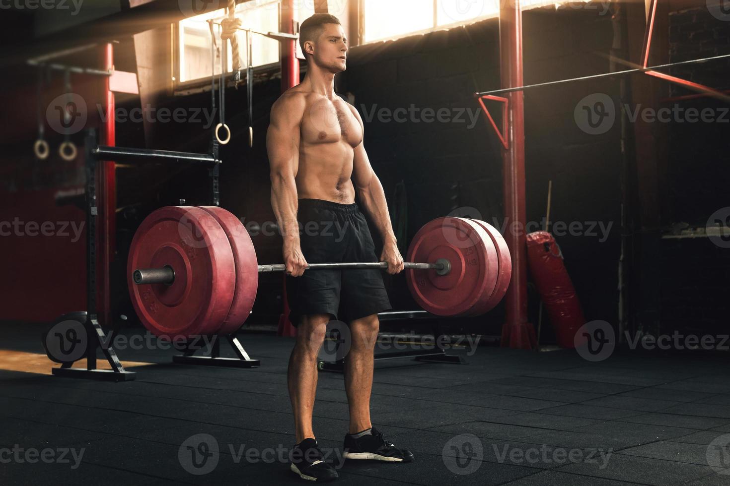 ejercicio de peso muerto. hombre durante su entrenamiento en el gimnasio foto