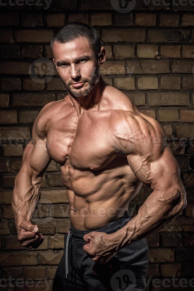 Man with muscular and sexy body against brick wall photo