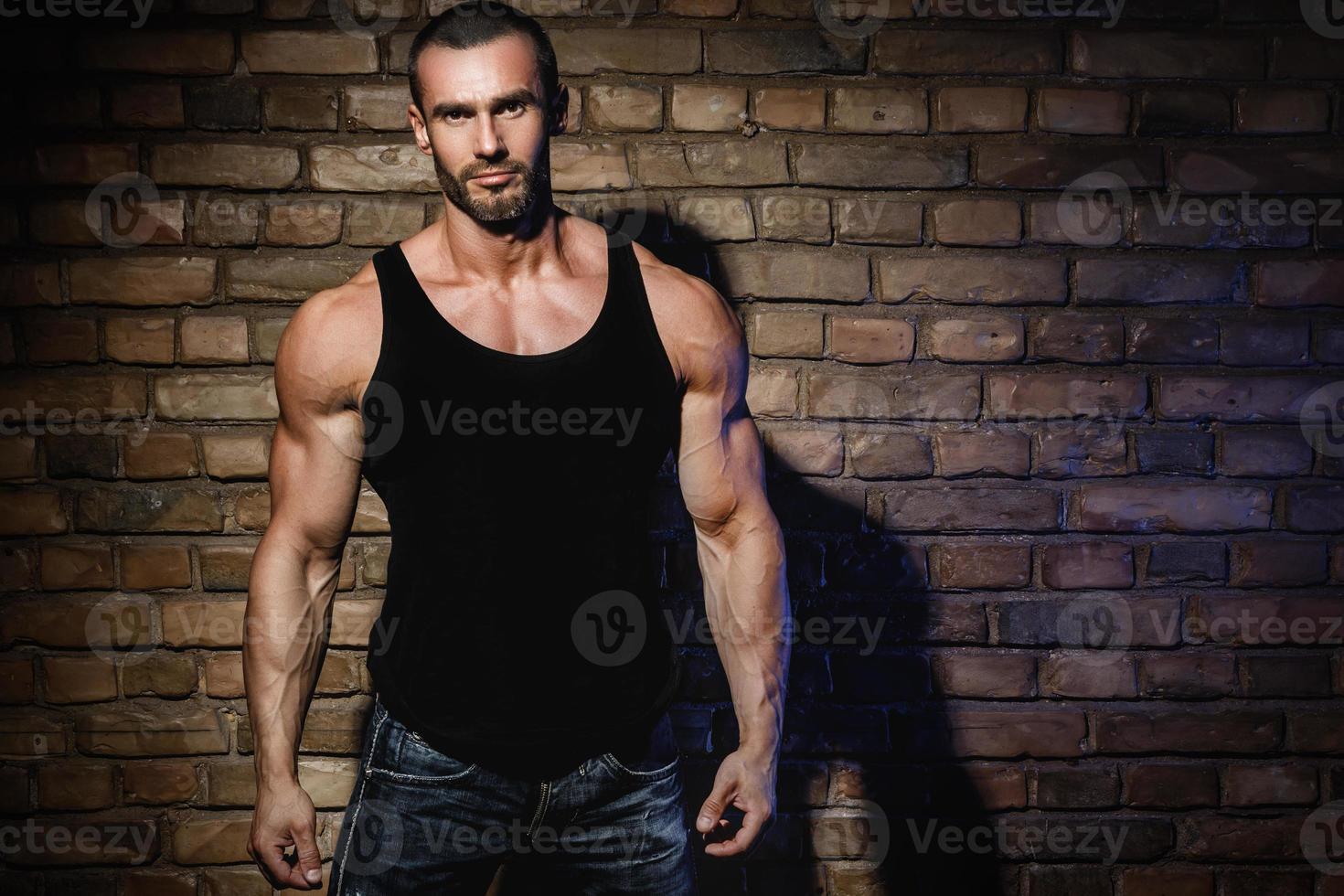 Bodybuilder wearing black tank top with empty space for your text or logo photo