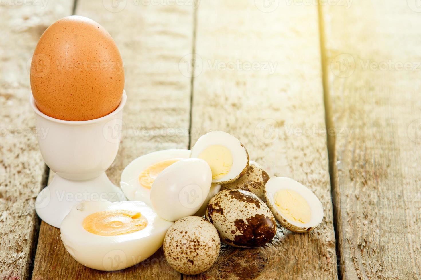 Quail and chicken eggs on the wooden table photo