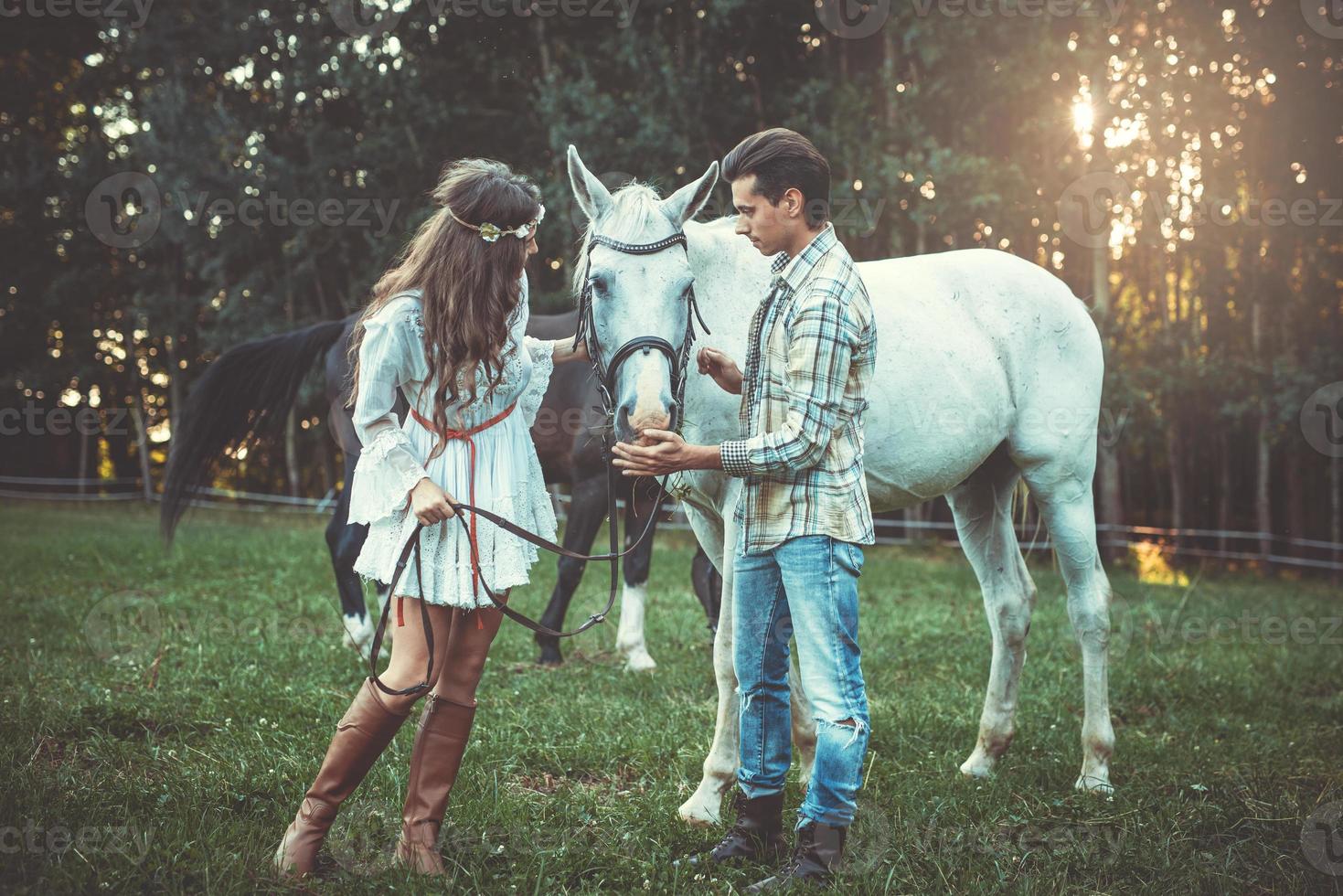 pareja joven cuidando un hermoso caballo foto