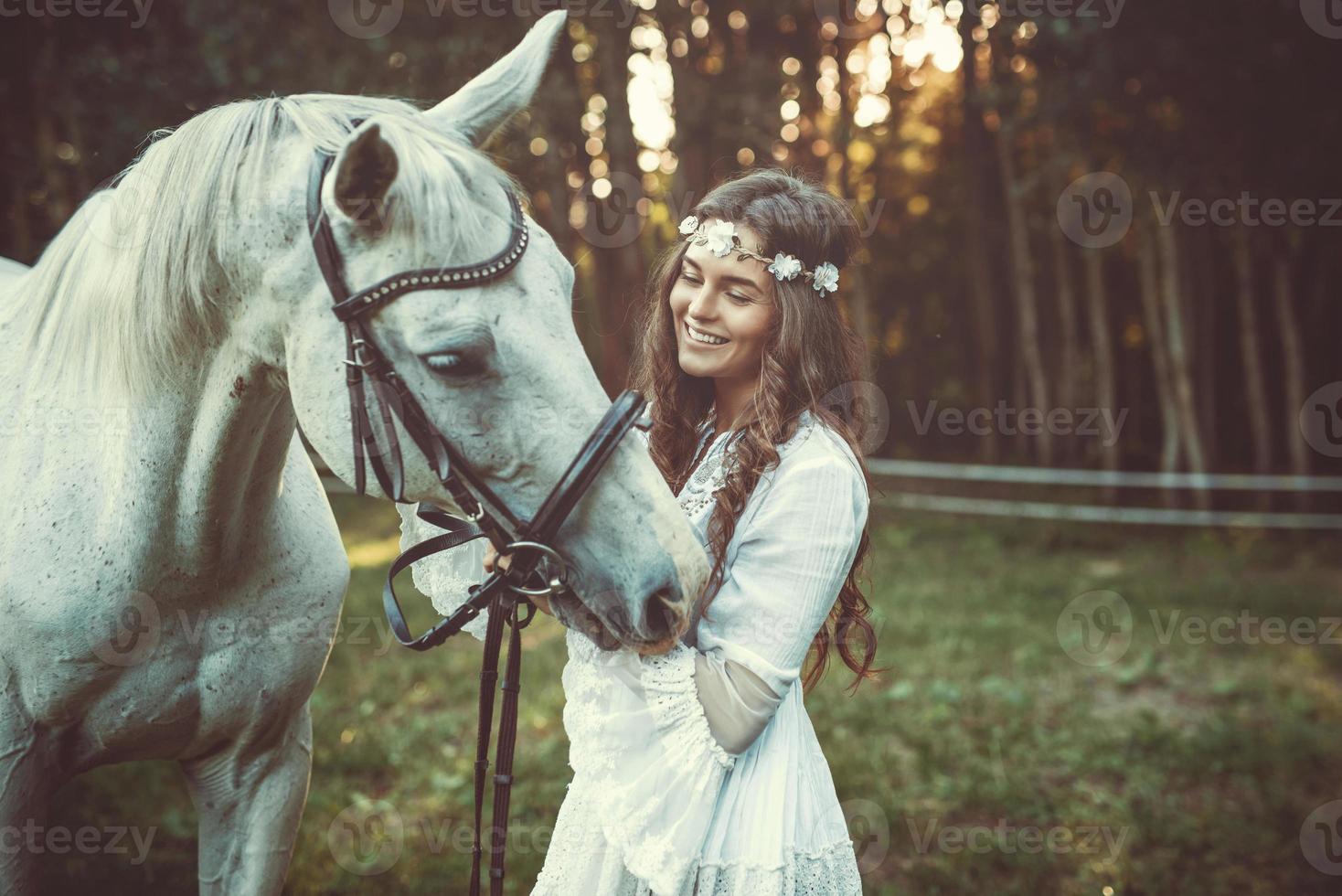 Young woman in beautiful white dress and her beautiful horse photo