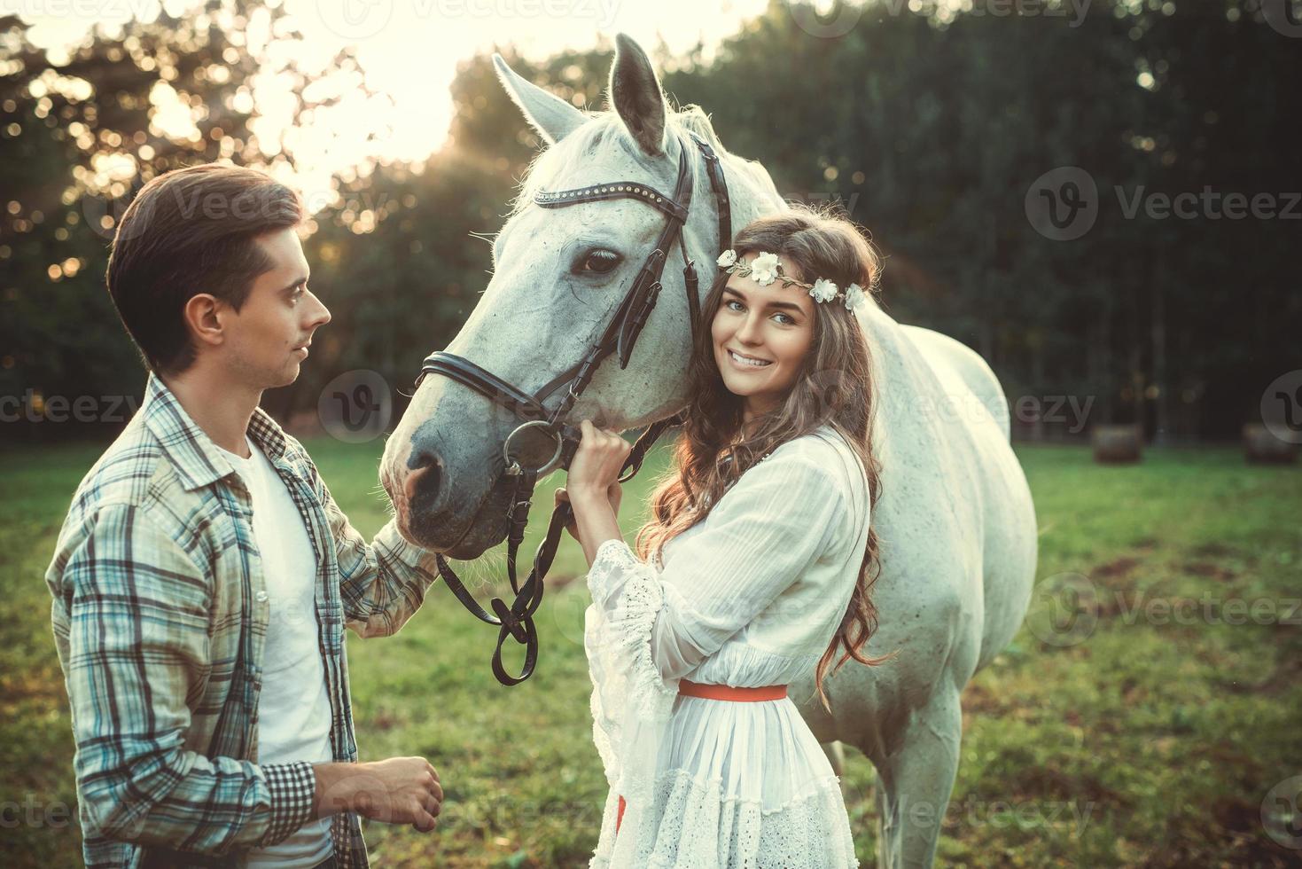 Young couple taking care about beautiful horse photo