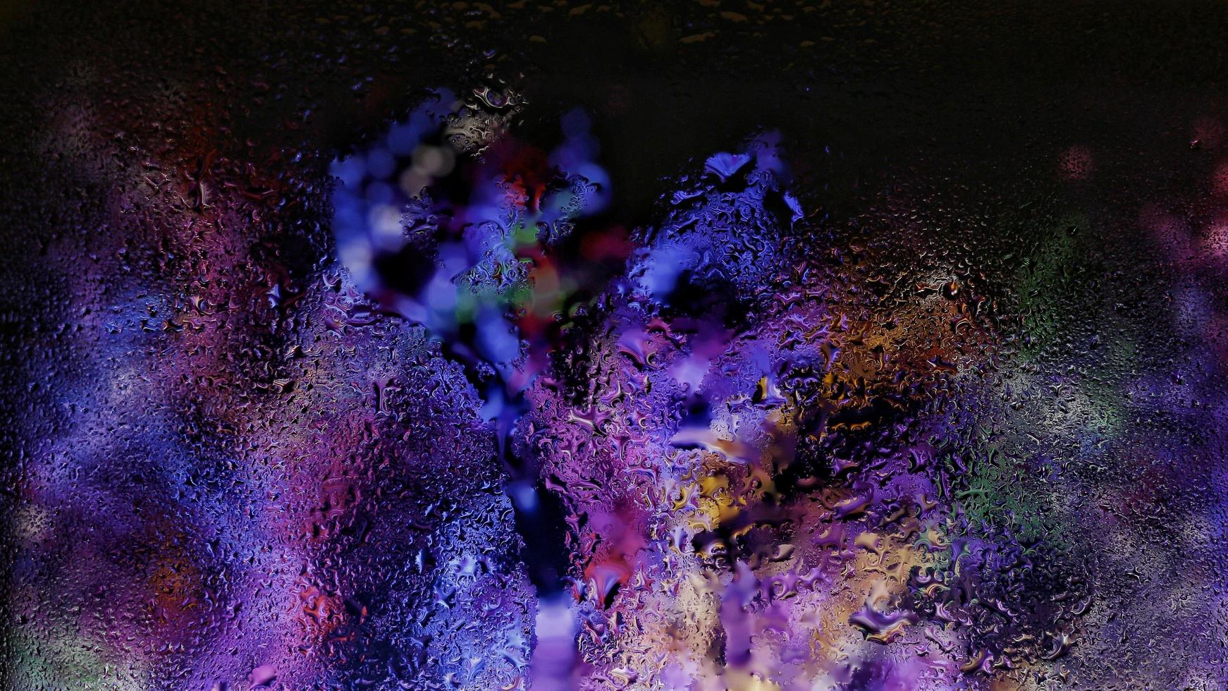 Purple Neon Blurred Lights Through Glass Window With Raindrops On It in Karachi Pakistan 2022 photo