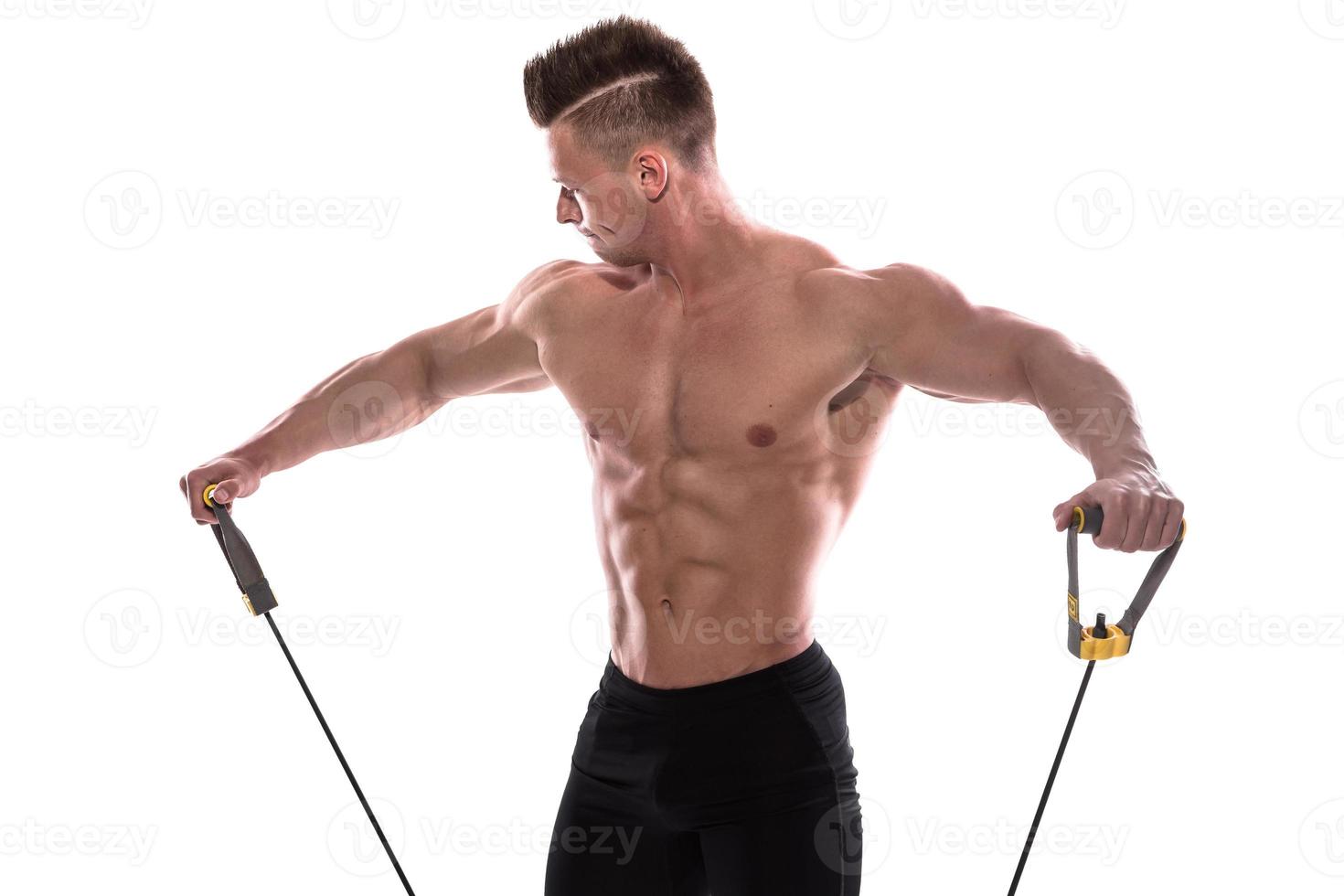 Bodybuilder working out with rubber band over white background photo