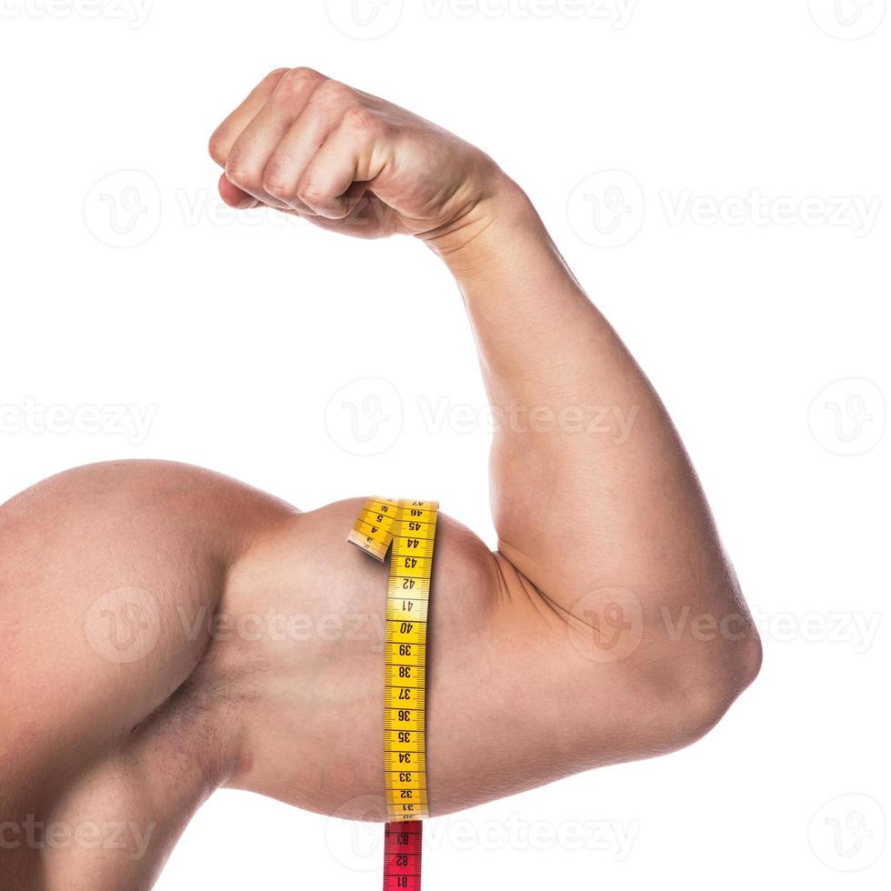Biceps and measuring tape on white background photo