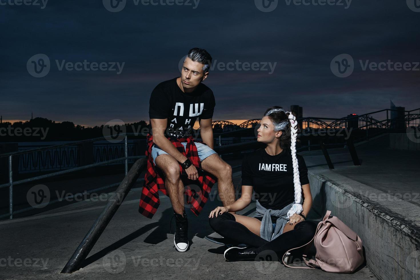 Stylish couple in the skate park at night photo