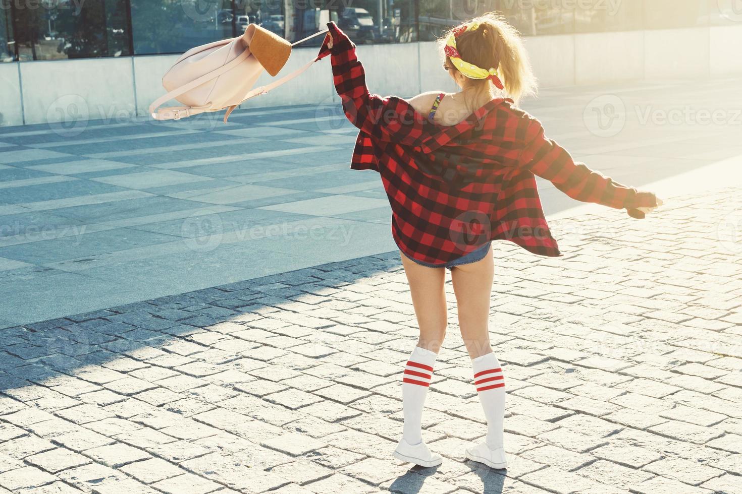 Happy stylish girl with backpack on street photo