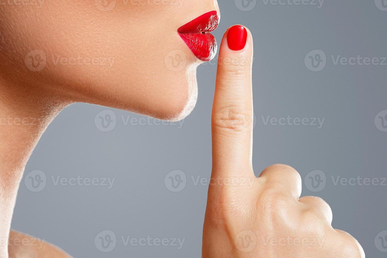 Woman is showing shush or silence gesture photo