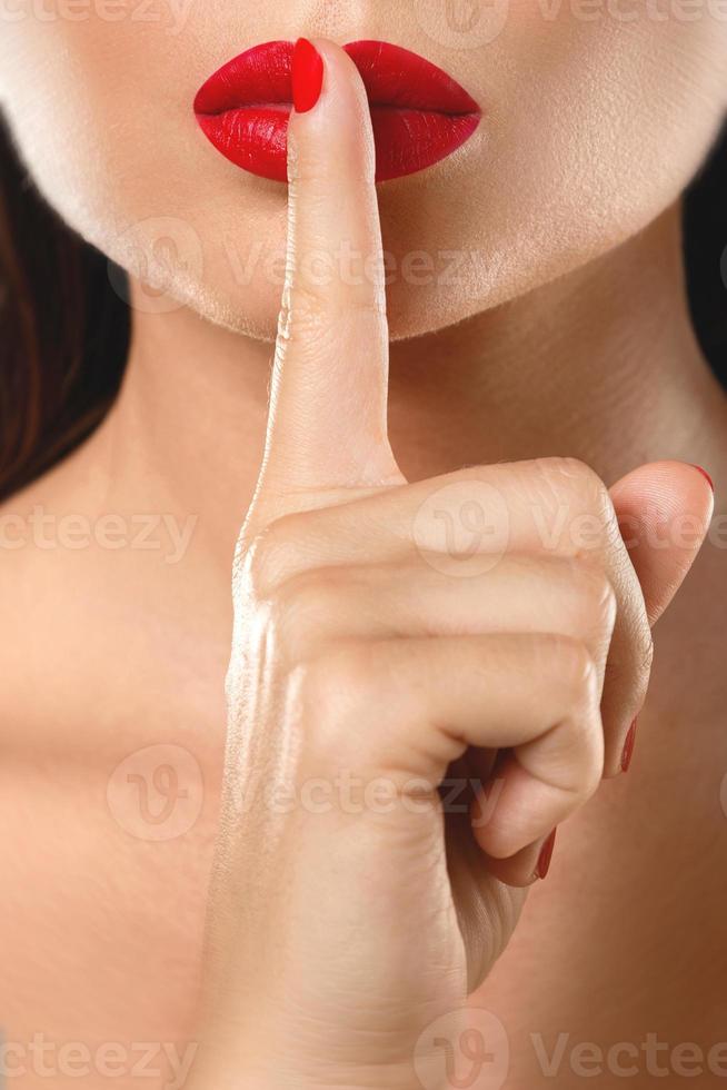 Woman is showing shush or silence gesture photo