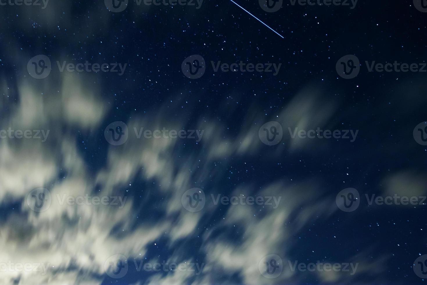 Night sky with stars and clouds in motion photo